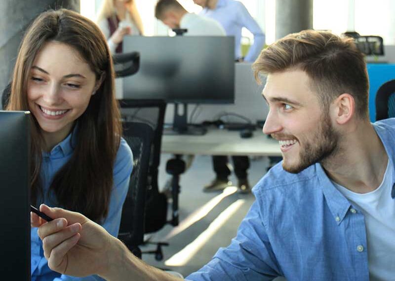 Two people collaborating on book writing, with a speech bubble icon containing text indicating writing services.