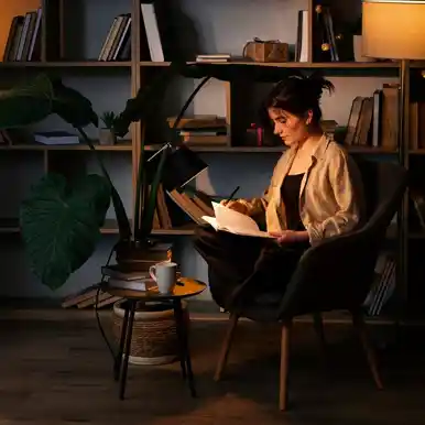 A woman writing in a notebook at home, representing the independent nature of self-publishing.