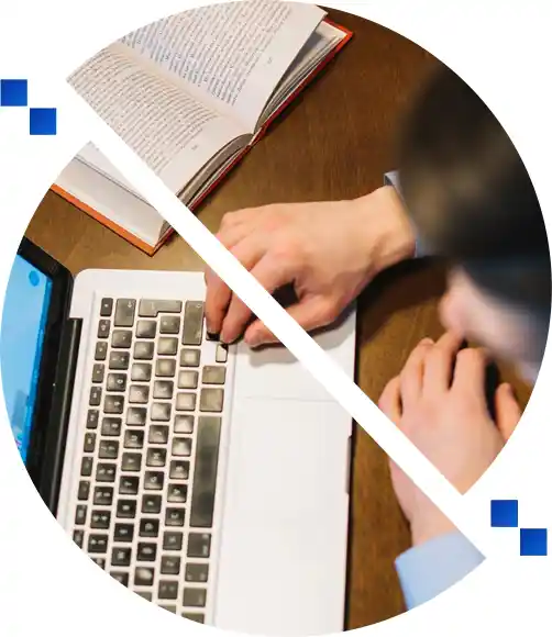 Person typing on a laptop next to an open book, representing the writing stage of self-publishing on Amazon.